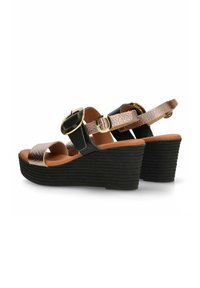 Sandalias de cuña con una base negra texturizada, que presentan tiras metálicas rosas y acentos redondos en dorado. Incluye hebilla ajustable en el tobillo.