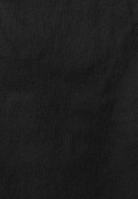 Texture de tissu noir uni avec un léger motif de tissage diagonal et de subtiles variations d'ombrage.