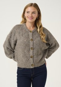 Pleteni cardigan v svetlo sivi barvi z teksturiranim vzorcem, s krožnim ovratnikom in petimi velikimi, okroglimi, rjavimi gumbi spredaj.