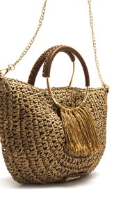 Bolso de mano de paja trenzada con correa de cadena dorada, asas de cuero marrón y detalle de borla. Cuenta con un anillo metálico redondo como adorno.