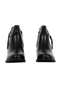 Paire de bottines en cuir noir avec fermetures éclair latérales et languettes tressées, vues de face sur fond blanc.