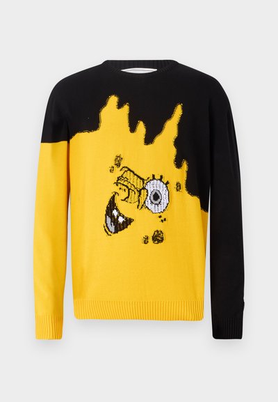 Pleteni pulover z črnim zgornjim delom in rumenim spodnjim delom z grafičnim dizajnom obraza lika in plamenov.