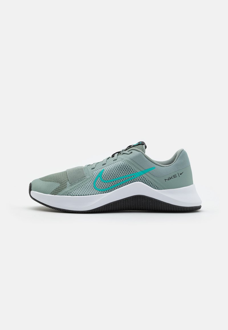 Zapatilla deportiva de Nike en un tono verde apagado, con materiales de malla y sintéticos, superficie texturizada, entresuela blanca y suela negra con acentos en color teal.