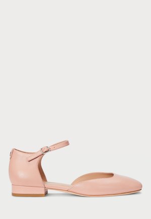 Enkele roze platte schoen met enkelriem en gesp, gesloten teen en kleine hak, getoond vanaf de rechterkant op een witte achtergrond.