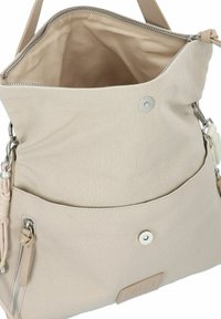 Beige Leinenshoppingtasche mit einem Reißverschluss oben, Vordertasche und silberfarbiger Hardware. Strukturiertes Äußeres mit glatter Innenauskleidung und Logopatch.
