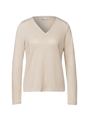 Haut à manches longues beige avec un col en V. Fabriqué en tissu tricoté texturé avec un léger éclat. coupe standard avec un ourlet droit.