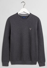 Ciemnoszary sweatshirt z teksturowanym wzorem w diamenty. Okrągły dekolt i ściągacze na rękawach. Małe czerwono-białe logo na piersi.