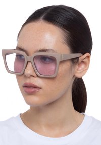 Occhiali da sole oversize beige con montatura quadrata e lenti rosa. Texture in plastica liscia con un sottile accento dorato sulle stanghette.