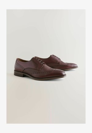 Braune Lederschuhe mit Flügelkappen-Design, perforierten Akzenten und glatter Oberfläche; verfügen über eine Schnürung und einen Holzabsatz.