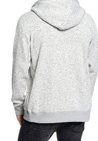 Szara bluza z kapturem wykonana z teksturowanej tkaniny o miękkiej, szczotkowanej strukturze. Posiada duży kaptur oraz ściągacze na dole i mankietach.