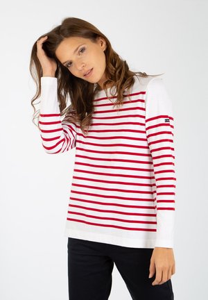 Chemise à manches longues rayée rouge et blanche avec un col rond, dotée d'un petit logo sur la manche et d'une coupe décontractée, fabriquée à partir d'un matériau doux.