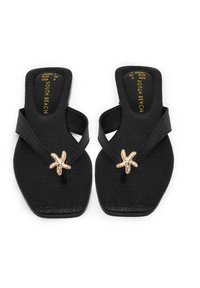 Infradito neri con superficie testurizzata, caratterizzati da un accento a forma di stella marina adornato con strass. Design a forma quadrata con una larga fascia.