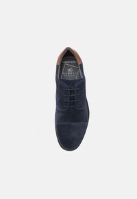 Scarpa in suede blu con una finitura liscia e dettagli in pelle marrone al tallone. Presenta un classico design con lacci e una forma della punta arrotondata.