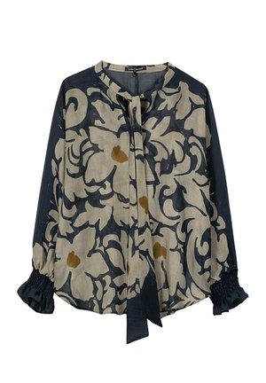 Long-sleeve blouse with beige and dark navy abstract floral pattern, round neckline, tie detail, and elastic ruffle cuffs.
