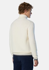 Cremfarbener Rollkragenpullover aus dickem Strick mit gerippten Bündchen und Saum, der schwarze und graue Streifen aufweist. Glatte Textur und bequeme Passform.