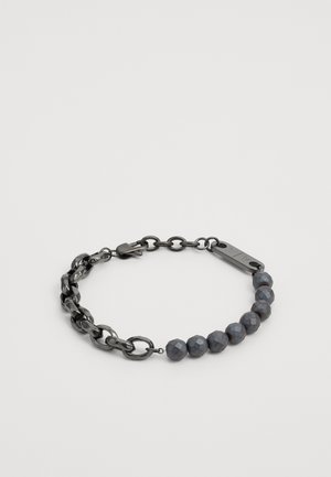 Käevõru, mis koosneb tumedast metallist ketilinkidest ja fašeeritud hallidest helmestest. Sulgemine on küüliku klamber koos metallmärgiga.