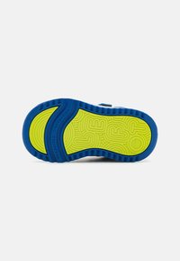 Sole in gomma blu e gialla con un motivo a onde, bordo scanalato e marchio in rilievo "VERSAFLEX" per trazione e presa.