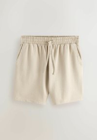 Shorts en tissu beige texturé avec taille élastique, cordon de serrage ajustable et poches latérales.