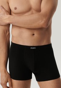 Czarne bokserki wykonane z miękkiej tkaniny, o dopasowanym kroju i elastycznym pasie z nazwą marki "ATLANTIC".