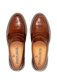 Mocasines de cuero marrón con un patrón de cocodrilo en la parte frontal, una punta lisa y costuras decorativas, con un detalle de marca en el interior.