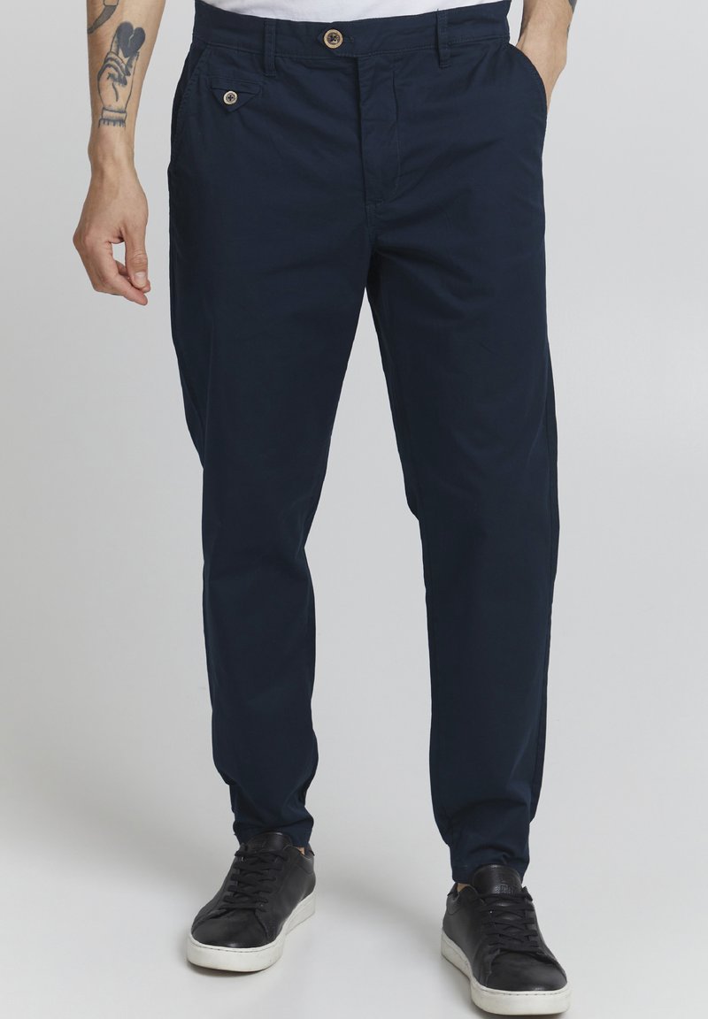 Mornarske modre hlače iz lahkega materiala, z gumbom za zapiranje, stranskima žepoma in slim fit obliko.