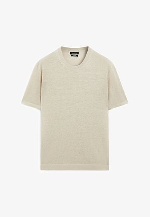 Jasno beżowa koszulka z krótkim rękawem, wykonana z miękkiego materiału, z okrągłym dekoltem, subtelną fakturą i luźnym krojem ze prostym wykończeniem dołu.