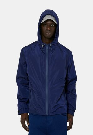 Giacca impermeabile blu navy con cappuccio, chiusura con zip, cordini regolabili al collo e tasche laterali. Texture liscia e design leggero.