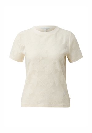 T-shirt crème à manches courtes en dentelle avec motif floral et encolure ronde, présenté sur un fond blanc.