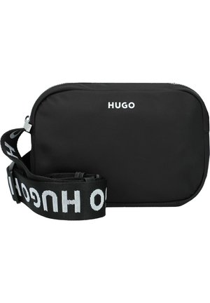 Musta suorakulmainen olkalaukku, jossa valkoinen HUGO-logo edessä ja säädettävä musta hihna, jossa toistuva valkoinen HUGO-kirjoitus.