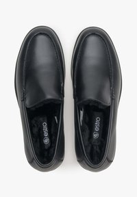 Czarne skórzane buty typu slip-on o gładkiej teksturze i zaokrąglonym przodzie. Miekka podszewka ze widocznym logo "estro" wewnątrz. Brak widocznych ozdób.