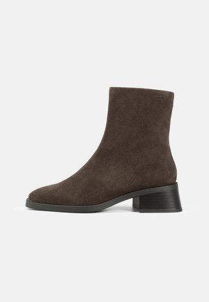 Bruine suede enkellaarsjes met een blokhak, voorzien van een gladde textuur en een ronde neus. Minimalistische esthetiek, geen zichtbare hardware.