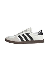 White athletic shoe with black three stripes design, made of leather and suede. Features a rubber sole and lace-up front.