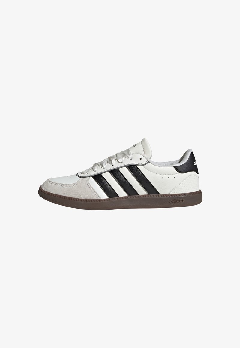 White athletic shoe with black three stripes design, made of leather and suede. Features a rubber sole and lace-up front.