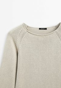 Lichtbeige gebreide trui met een ronde halslijn, gestructureerde stof en raglanmouwen. Label zichtbaar binnen de kraag.