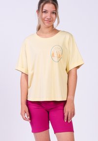 Geel katoenen t-shirt met een ronde afbeelding van bergen en bomen, gecombineerd met fuchsia knie-lange shorts. Casual ontwerp en pasvorm.