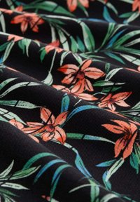 Kwiatowy materiał na czarnym tle, z pomarańczowymi liliami i zielonymi liśćmi. Tekstura wydaje się gładka z subtelnym połyskiem.