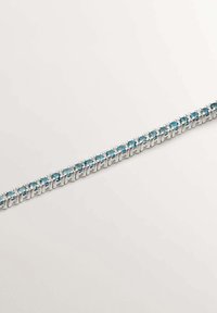 Pulsera de tono plateado que presenta una serie de gemas redondas de color azul claro engastadas en eslabones de metal alternos. Textura suave con un cierre seguro.