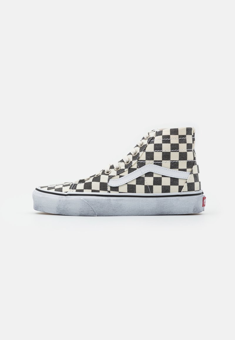 Baskets montantes à carreaux en toile noire et crème avec un swoosh en cuir blanc, semelle en caoutchouc grise et lacets plats.
