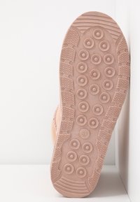 Suela de zapato en color rosa claro con un patrón de agarre circular y bordes texturizados. Marcada con la talla 37. Material de goma suave.