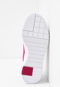 Semelle de sneaker blanche avec des motifs texturés et un logo carré rouge près du talon, sur un fond blanc à coins.