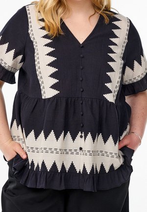 Schwarz-cremefarbene Bluse mit V-Ausschnitt, kurzen Ärmeln, Knopfdetails und gerafftem Saum mit Zickzack- und stichähnlichen Mustern.
