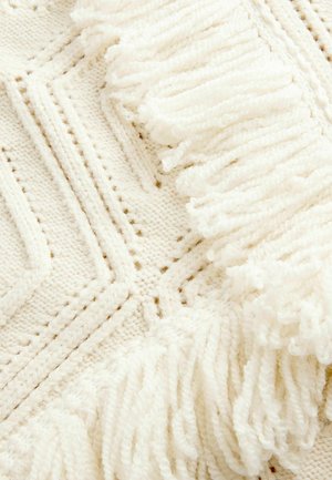 Strickdecke in Creme mit geometrischen Mustern, ausgestattet mit strukturierten Fransen an einer Kante, die weiche, flauschige Garne präsentiert.