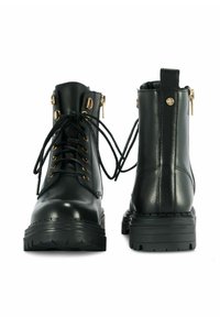 Czarne skórzane botki za kostkę z złotymi akcentami, okrągłymi sznurowadłami i teksturowaną gumową podeszwą. Posiadają boczny zamek błyskawiczny i wyściełany kołnierz.