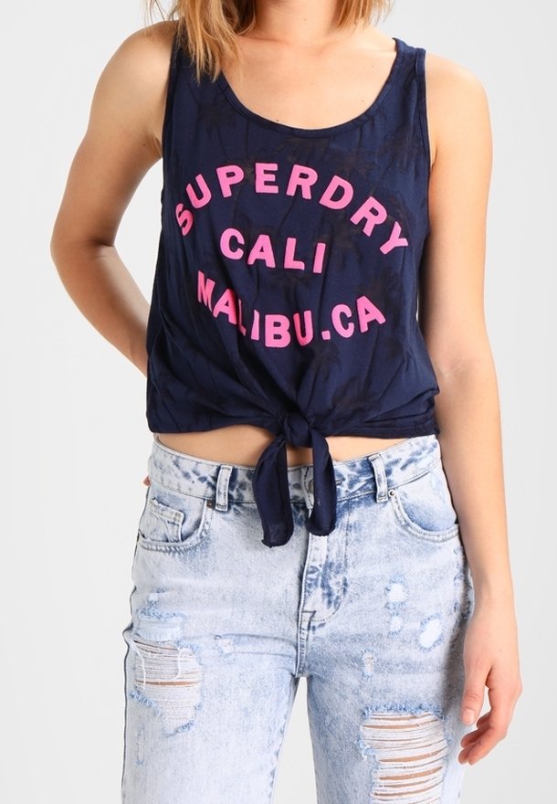 Marinblå cropped linne med knuten framsida, rosa fet stil med texten "SUPERDRY CALI MALIBU.CA," i en mjuk, texturerad tyg.