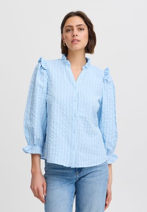 Cămașă button-up de culoare albastră deschisă, cu umeri flarați, dungi verticale texturate și mâneci până la trei sferturi, confecționată dintr-un material moale.