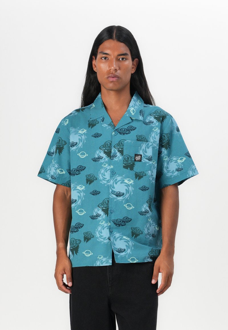 Korte mouw knoopsluiting shirt in teal stof, met golvende patronen in zwart en crème. Inclusief een borstzak met een logo label.