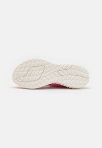 Baskets roses avec une semelle extérieure en caoutchouc blanc texturé. La semelle présente un motif antidérapant pour une meilleure adhérence. La partie supérieure est colorée et flexible.