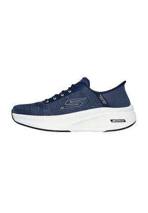 Zapatilla deportiva de punto azul con entresuela blanca, punta redonda, suela negra y detalles en verde brillante en los cordones. Presenta una textura suave y un diseño ligero.
