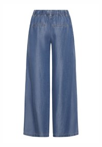 Pantaloni denim albastri cu talie elastică și croială largă pe picior, cu două buzunare cu șliț în spate, vizualizați din spate pe un fundal alb.