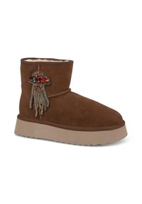 Bottine en daim marron avec doublure en peluche, présentant un design de méduse orné de perles colorées et d'une semelle texturée.
